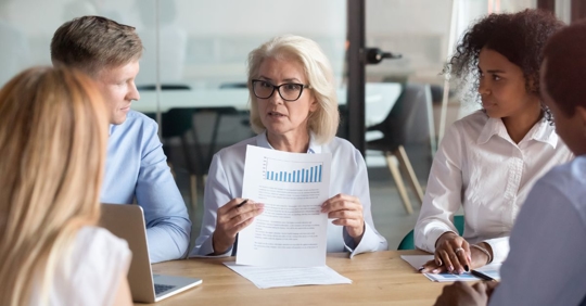 older employee showing data at work